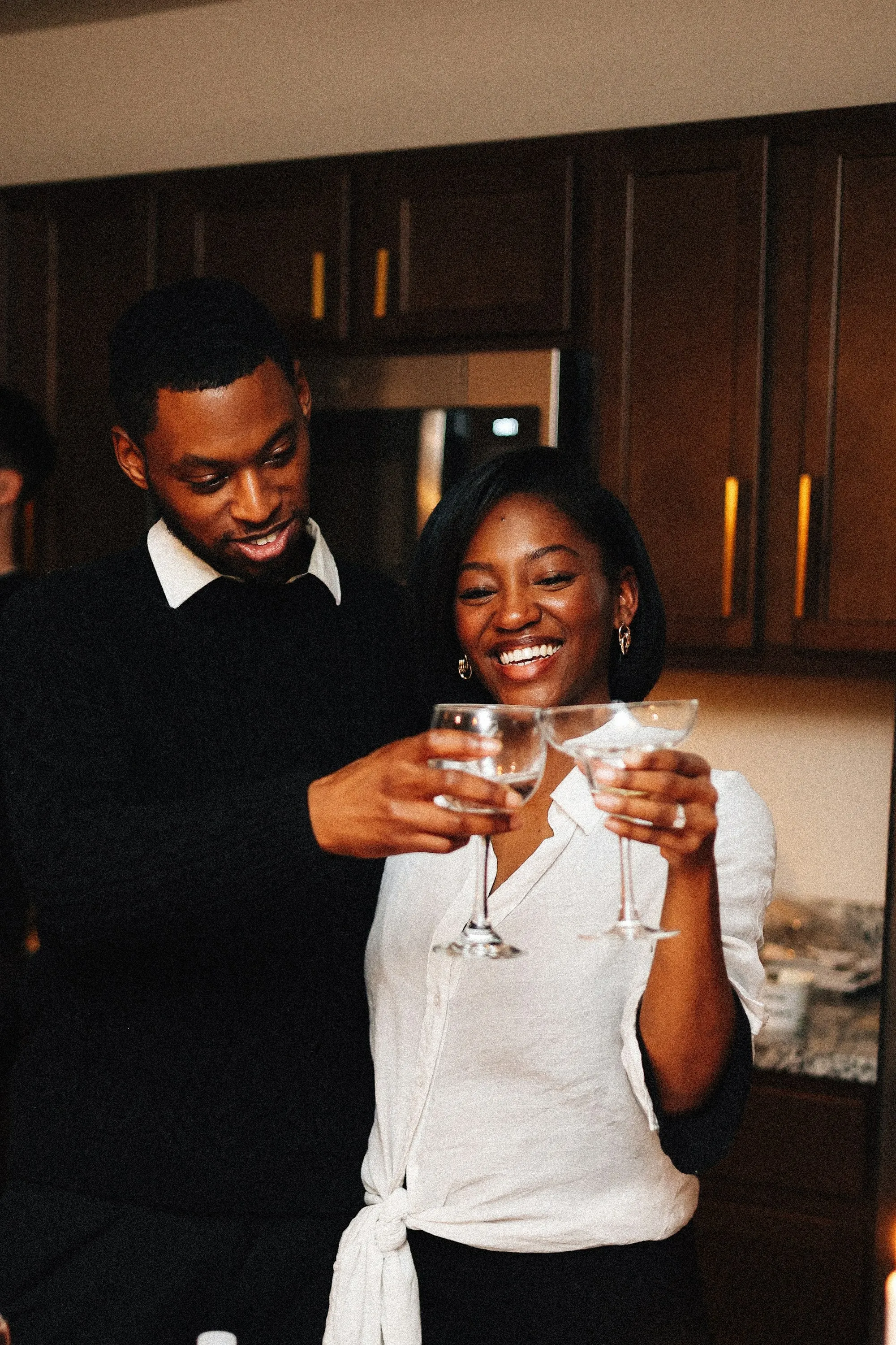 Couple smiling and toasting together in their kitchen